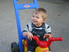 Jarrod rides Nana's tricycle.