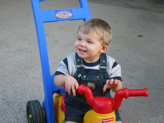 Jarrod rides Nana's tricycle.